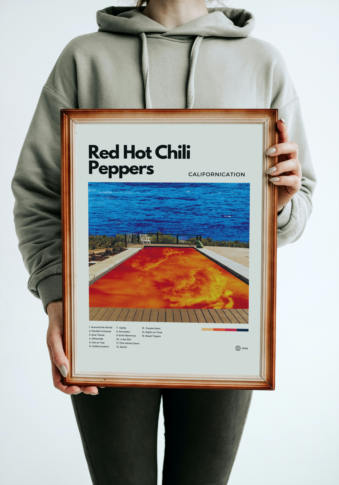 Person holding a framed poster of Red Hot Chili Peppers' 'Californication' album cover.