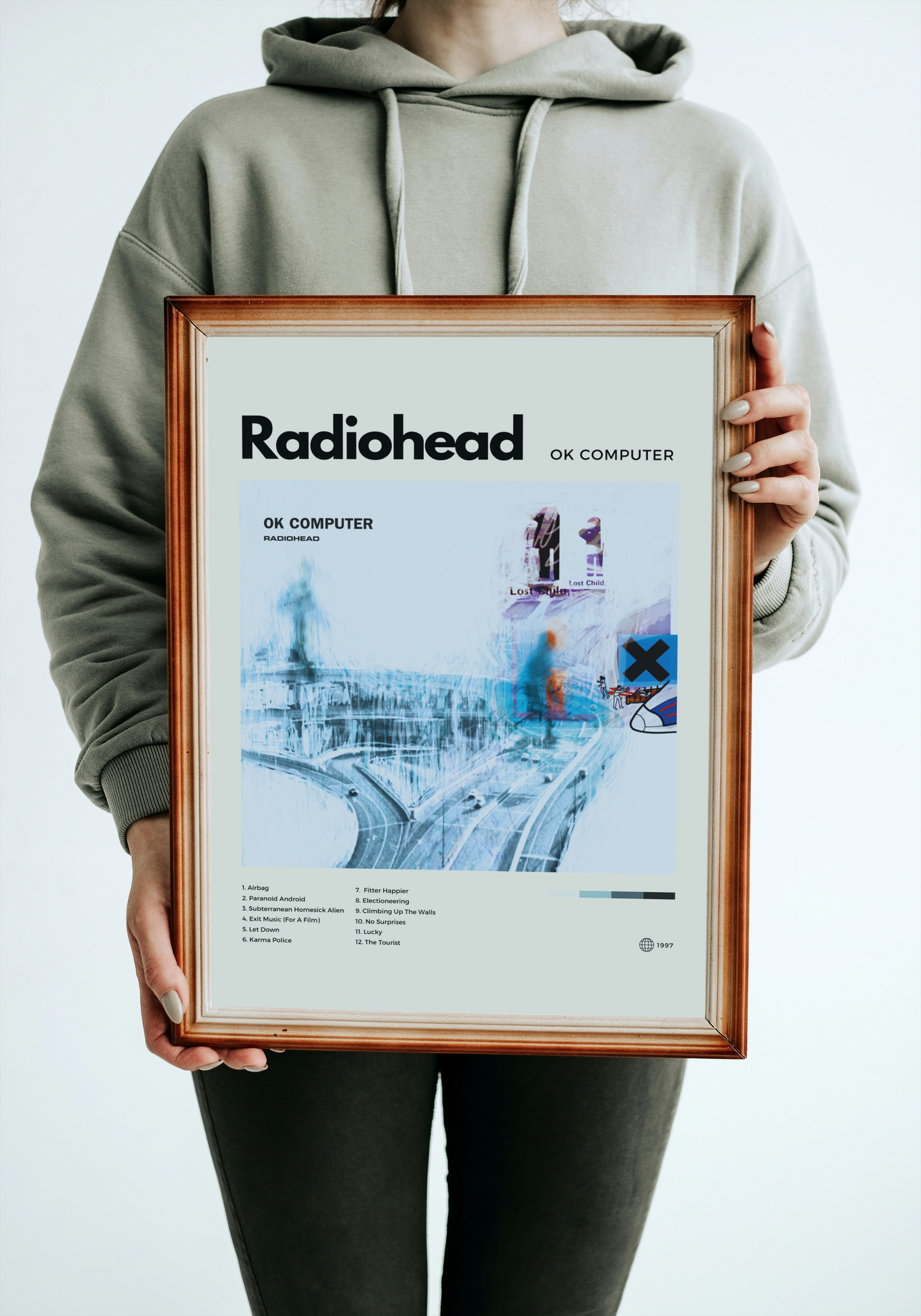 Person holding a framed Radiohead 'OK Computer' album cover
