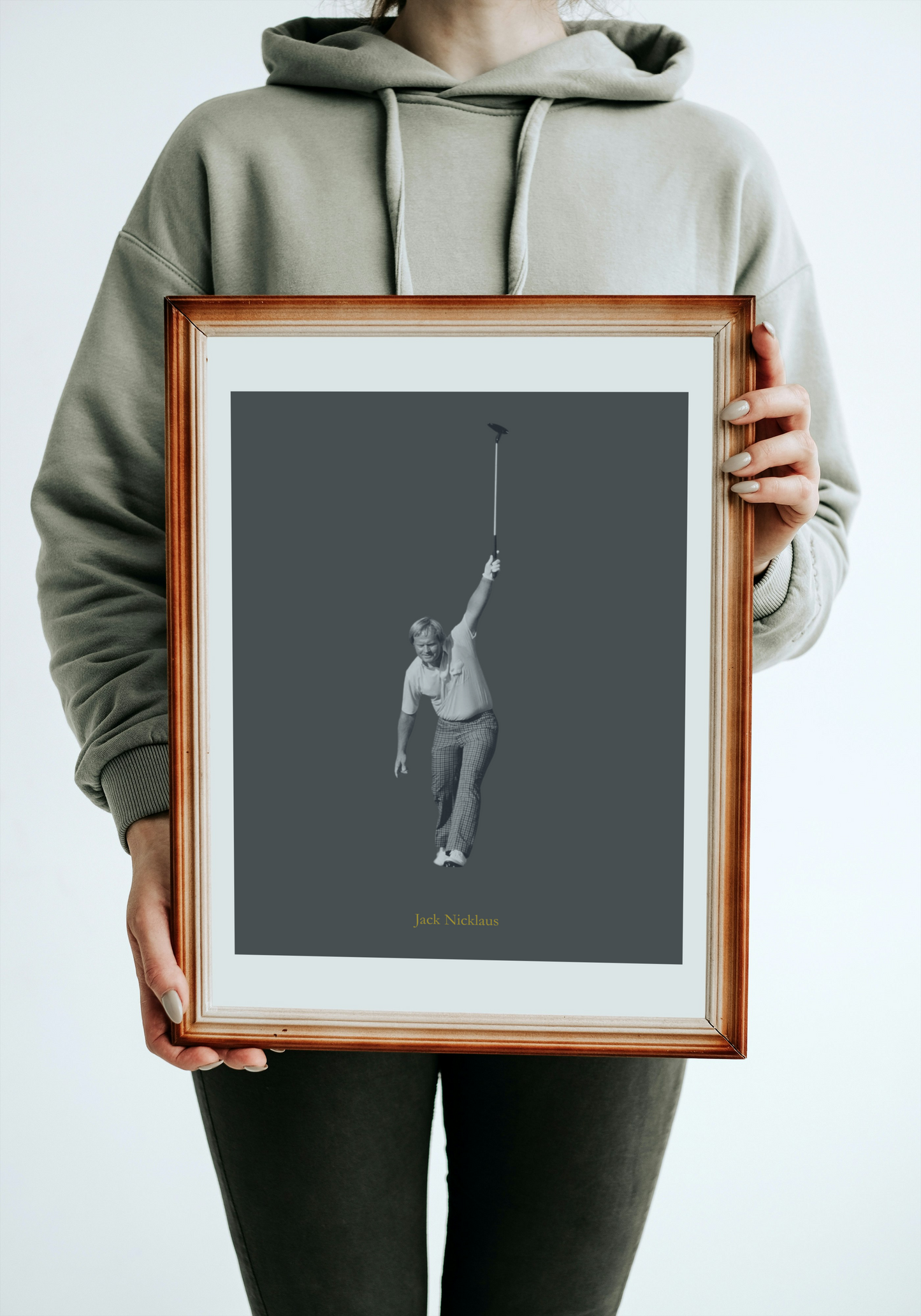 Person holding a framed black and white photograph of Jack Nicklaus against a gray background