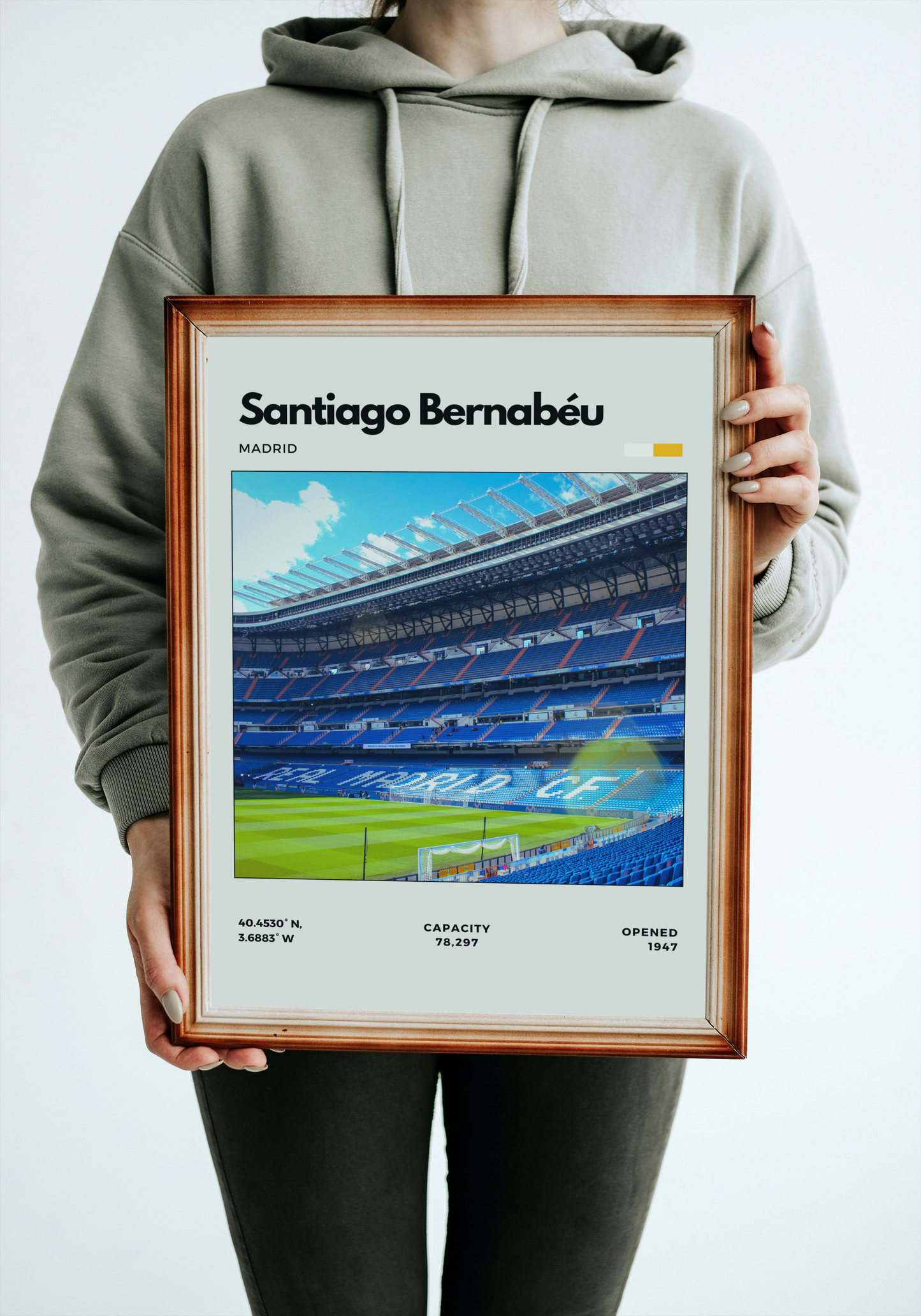 Person holding a framed poster of Santiago Bernabéu stadium