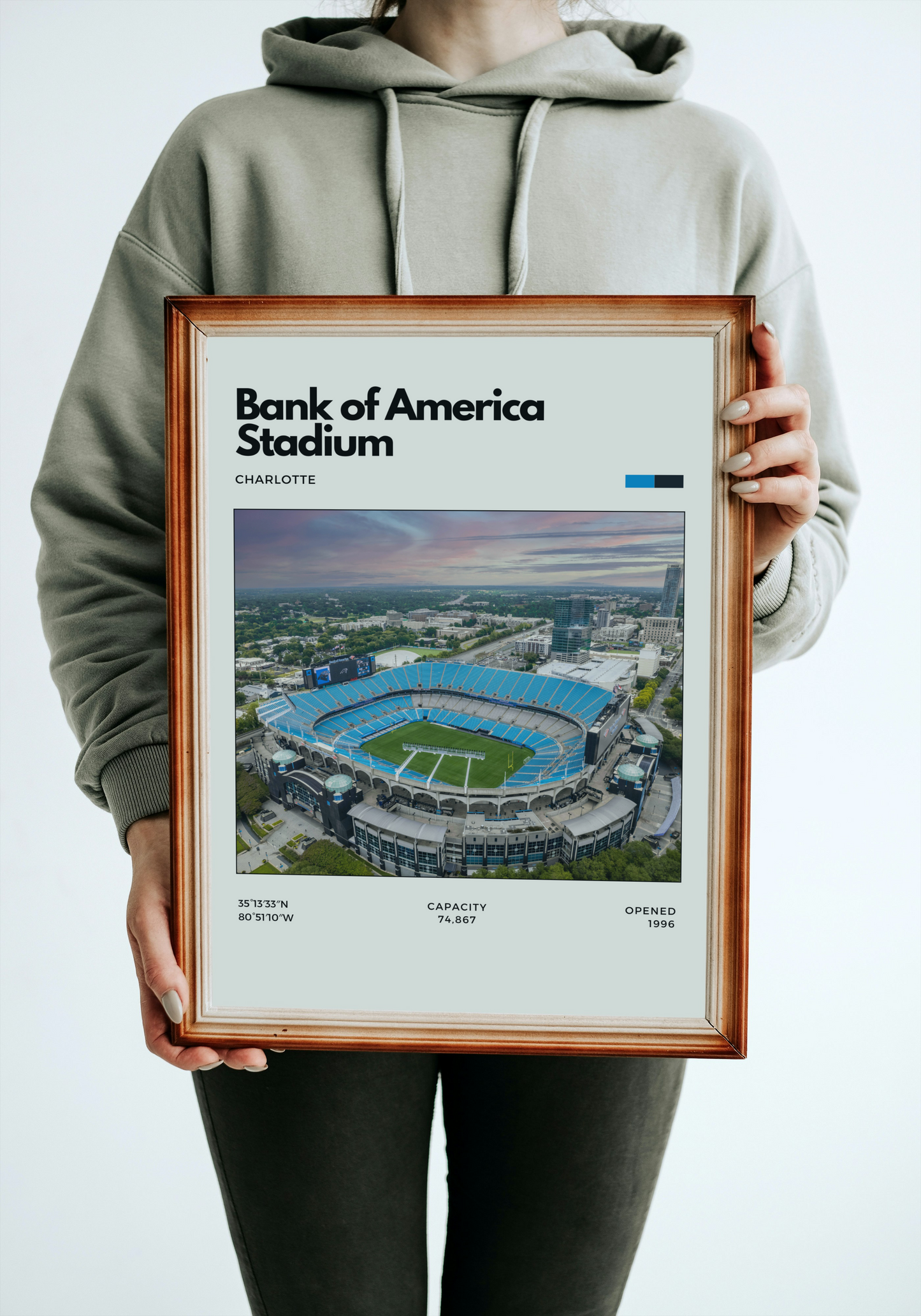 Person holding a framed poster of Bank of America Stadium