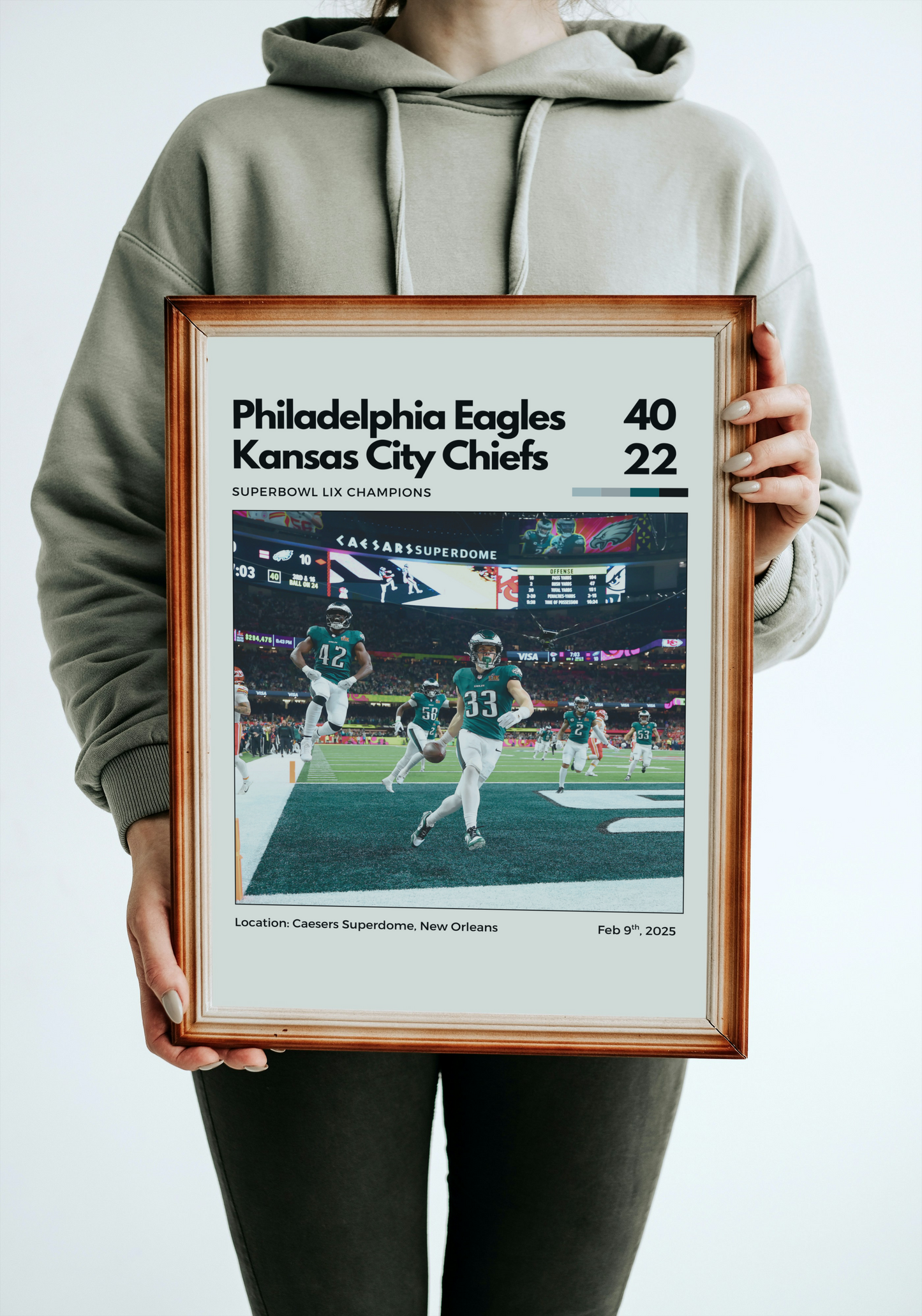 Person holding a framed print of a Philadelphia Eagles vs Kansas City Chiefs game, showing a score of 40-22.