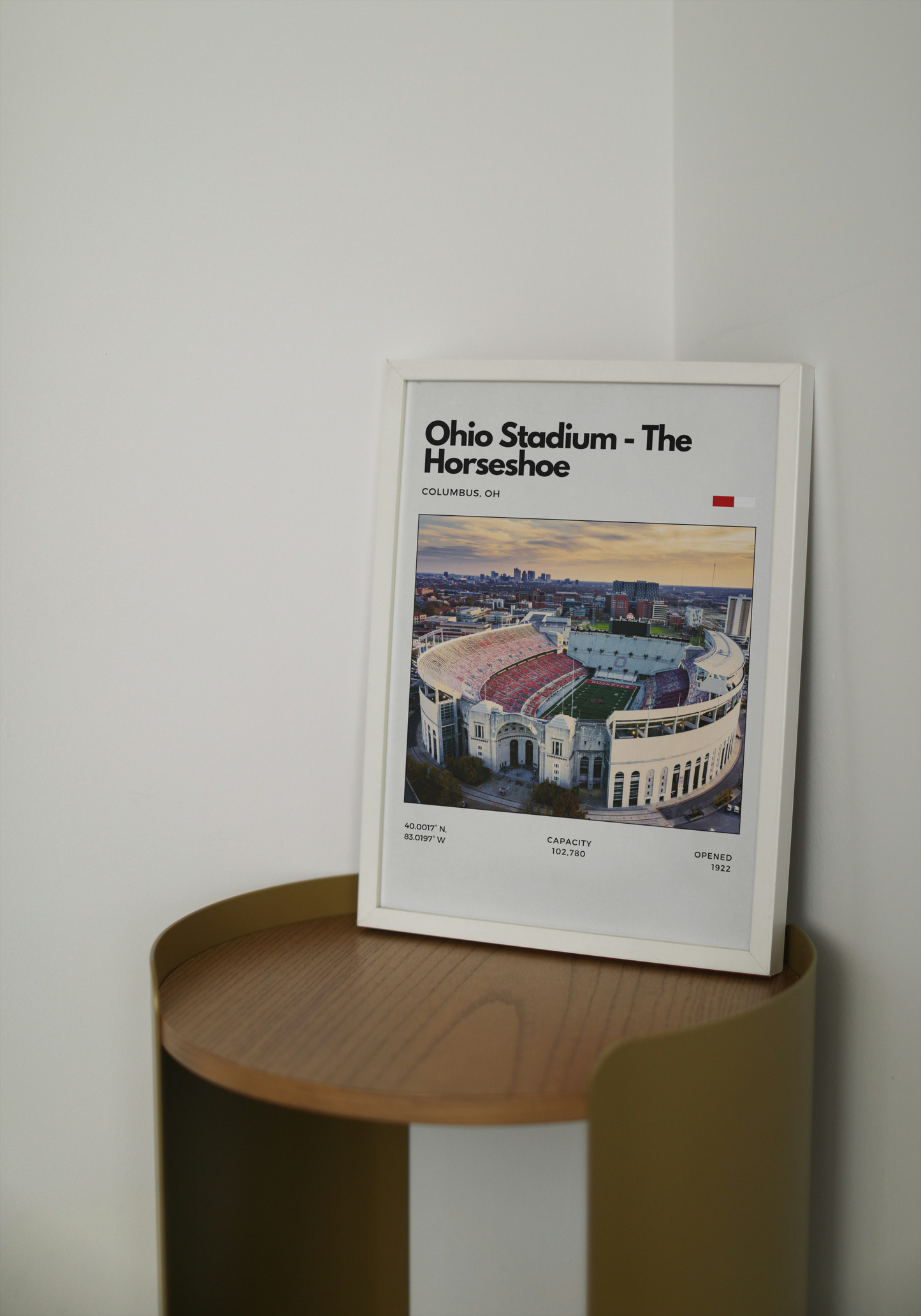 Framed poster of Ohio Stadium on a wooden shelf against a white wall