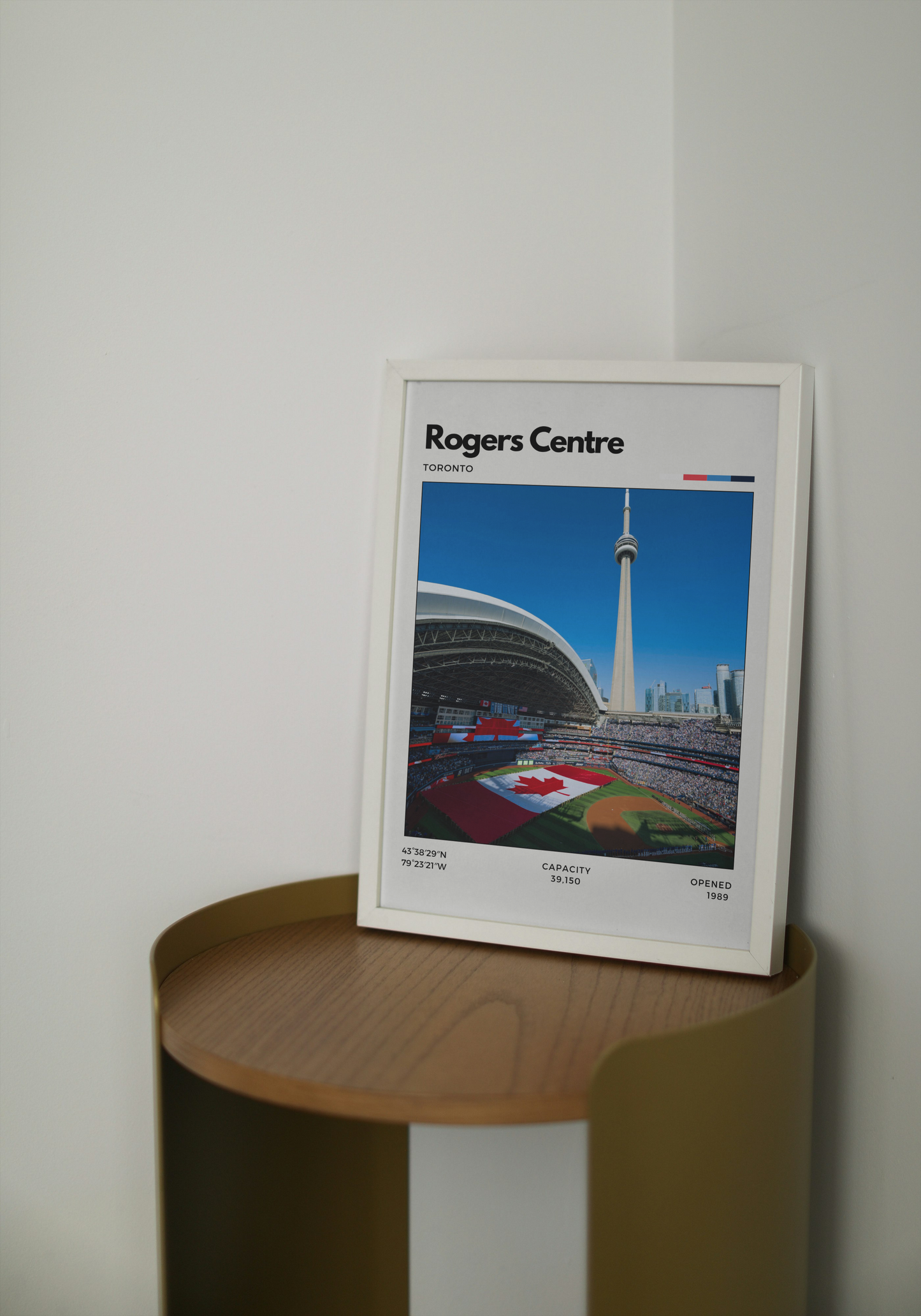 Framed poster of Rogers Centre on a wooden shelf against a white wall
