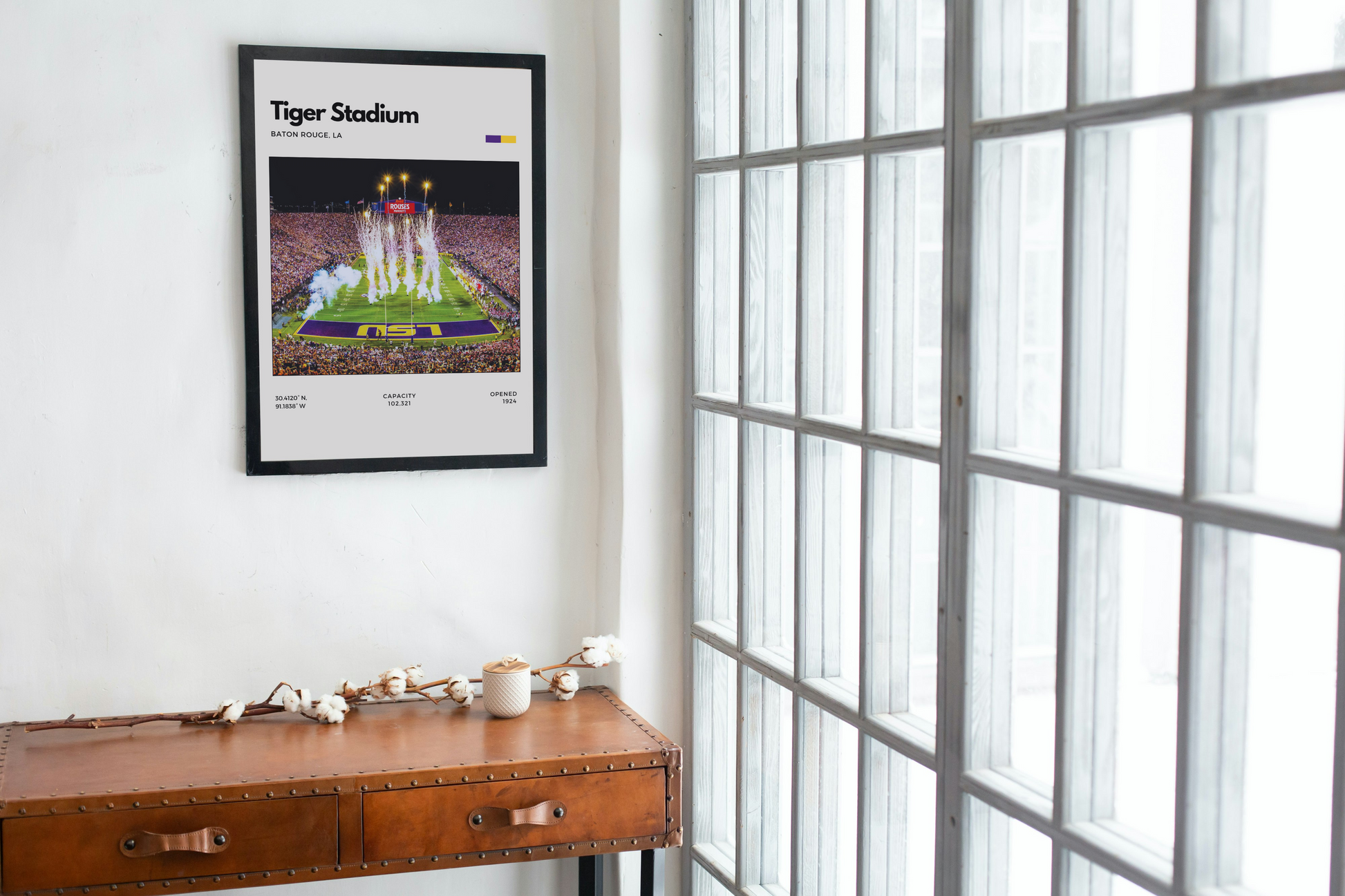 Framed poster of Tiger Stadium on a wall above a wooden desk.