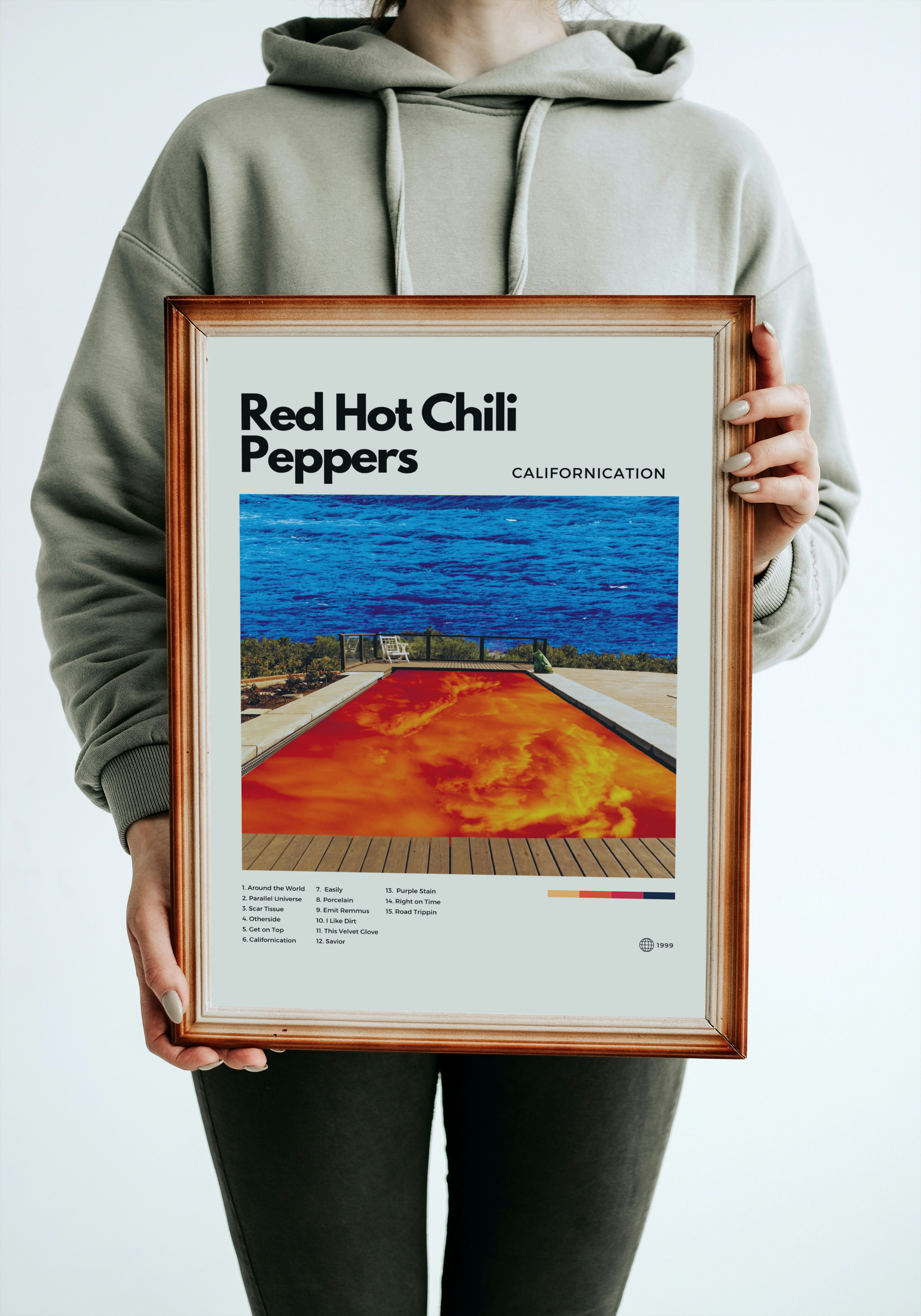Person holding a framed poster of Red Hot Chili Peppers' 'Californication' album cover.