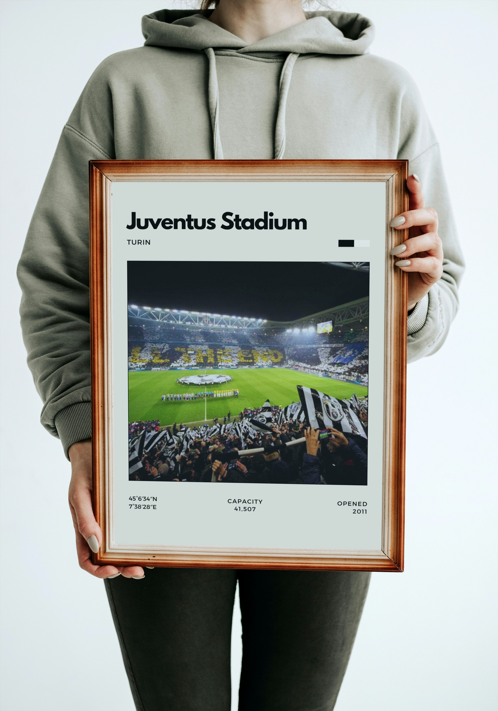 Person holding a framed poster of Juventus Stadium