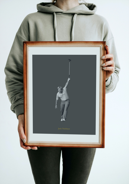 Person holding a framed black and white photograph of Jack Nicklaus against a gray background