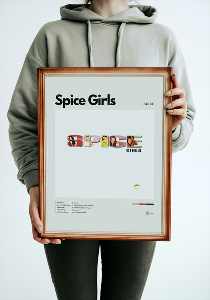 Person holding a framed 'Spice Girls' poster with a plain background