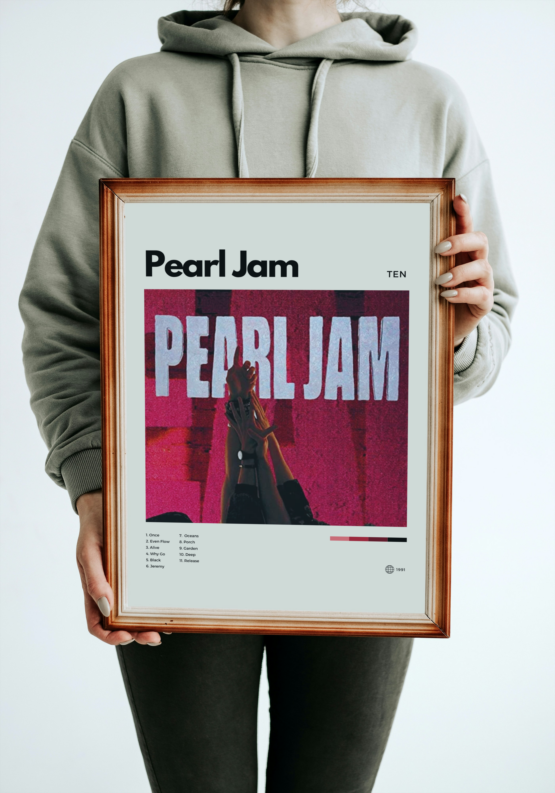 Person holding a framed Pearl Jam album cover against a white background