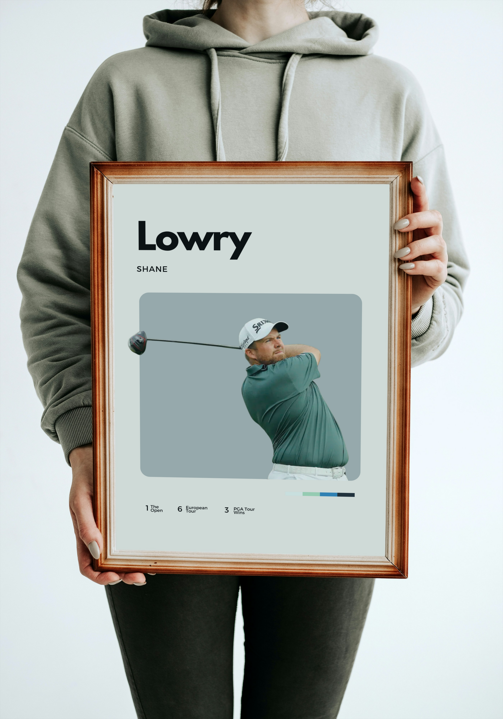 Person holding a framed picture of a golfer with 'Lowry' and 'Shane' text.