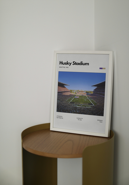 Framed poster of Husky Stadium on a wooden shelf against a white wall
