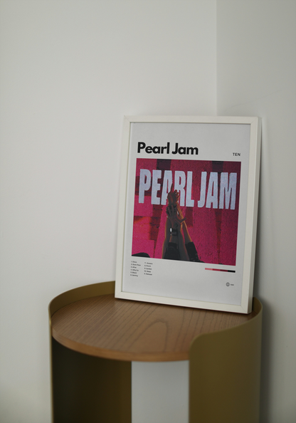 Framed Pearl Jam poster on a wooden shelf against a white wall