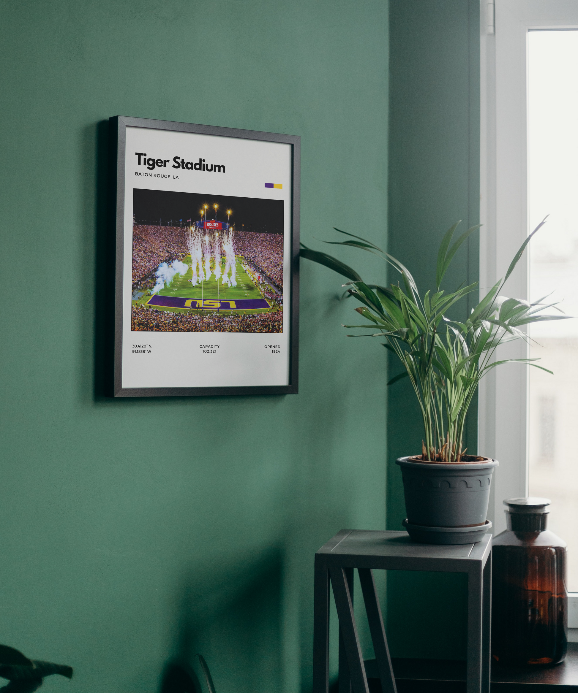 Framed poster of Tiger Stadium on a green wall with a plant and window in the background